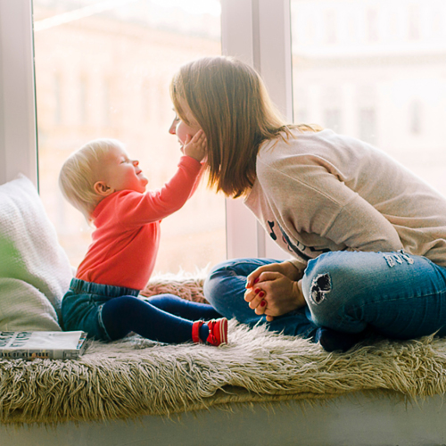 Bebé com mãos na cara do adulto a sorrir