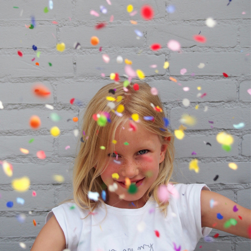 Criança a sorrir com confetis