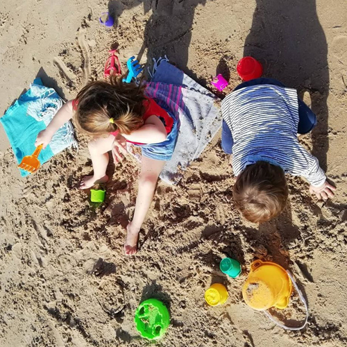 Crianças a brincar na areia da praia