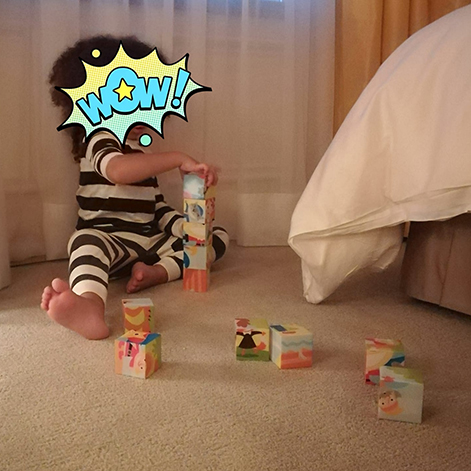 Criança a brincar fazendo uma torre de cubos